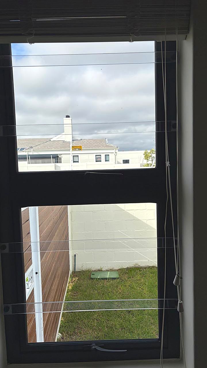 White horizontal steel burglar bars on a small residential window