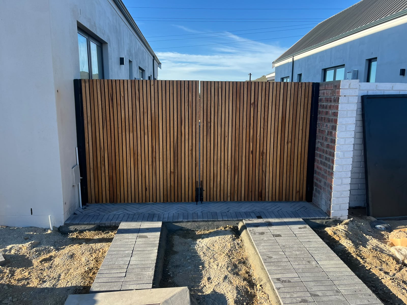 Custom swing driveway gate with vertical timber slats installed in Paarl