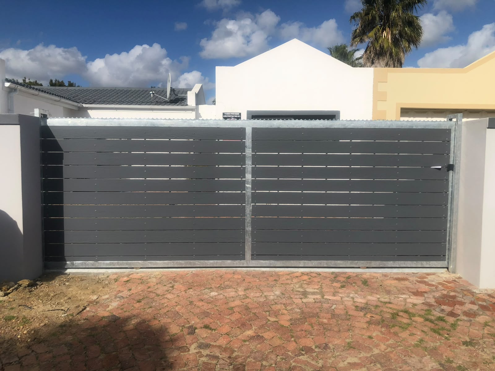 Sliding driveway gate with dark horizontal slats installed in Parklands, Cape Town
